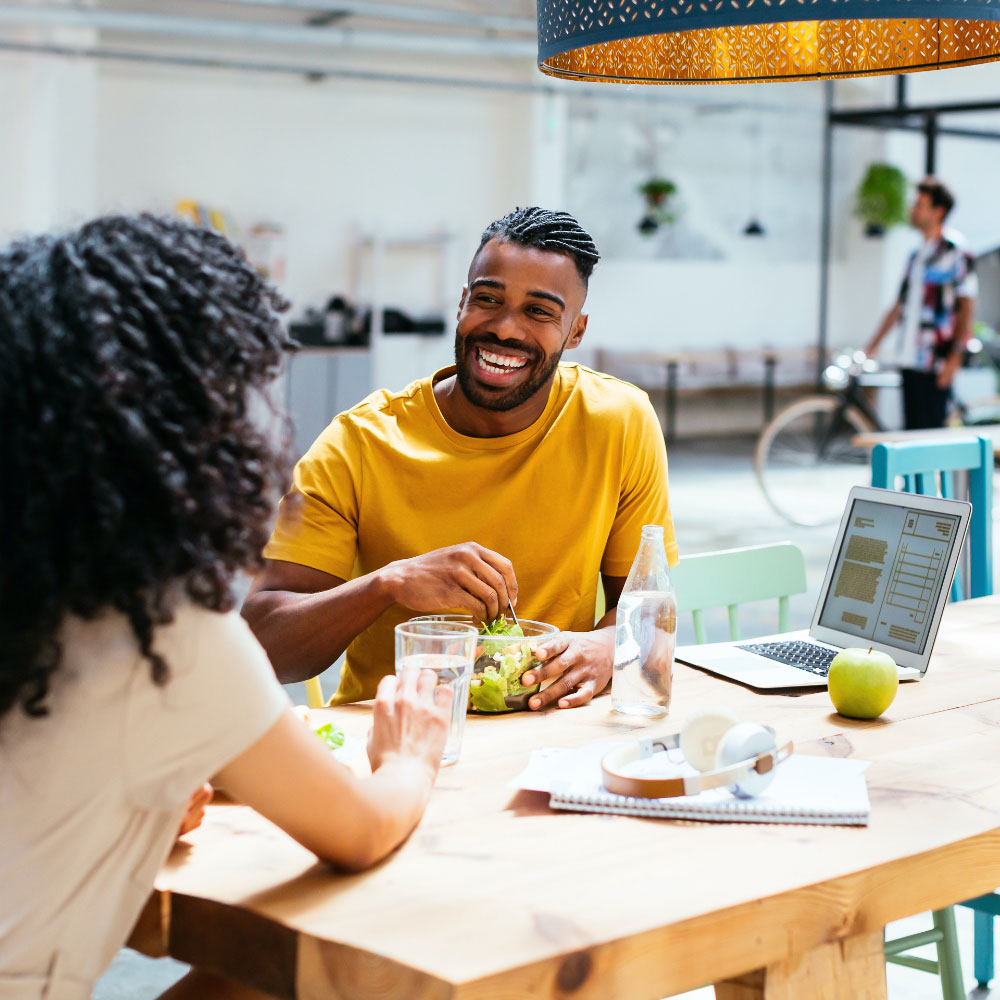 An African-American couple laugh together over lunch 